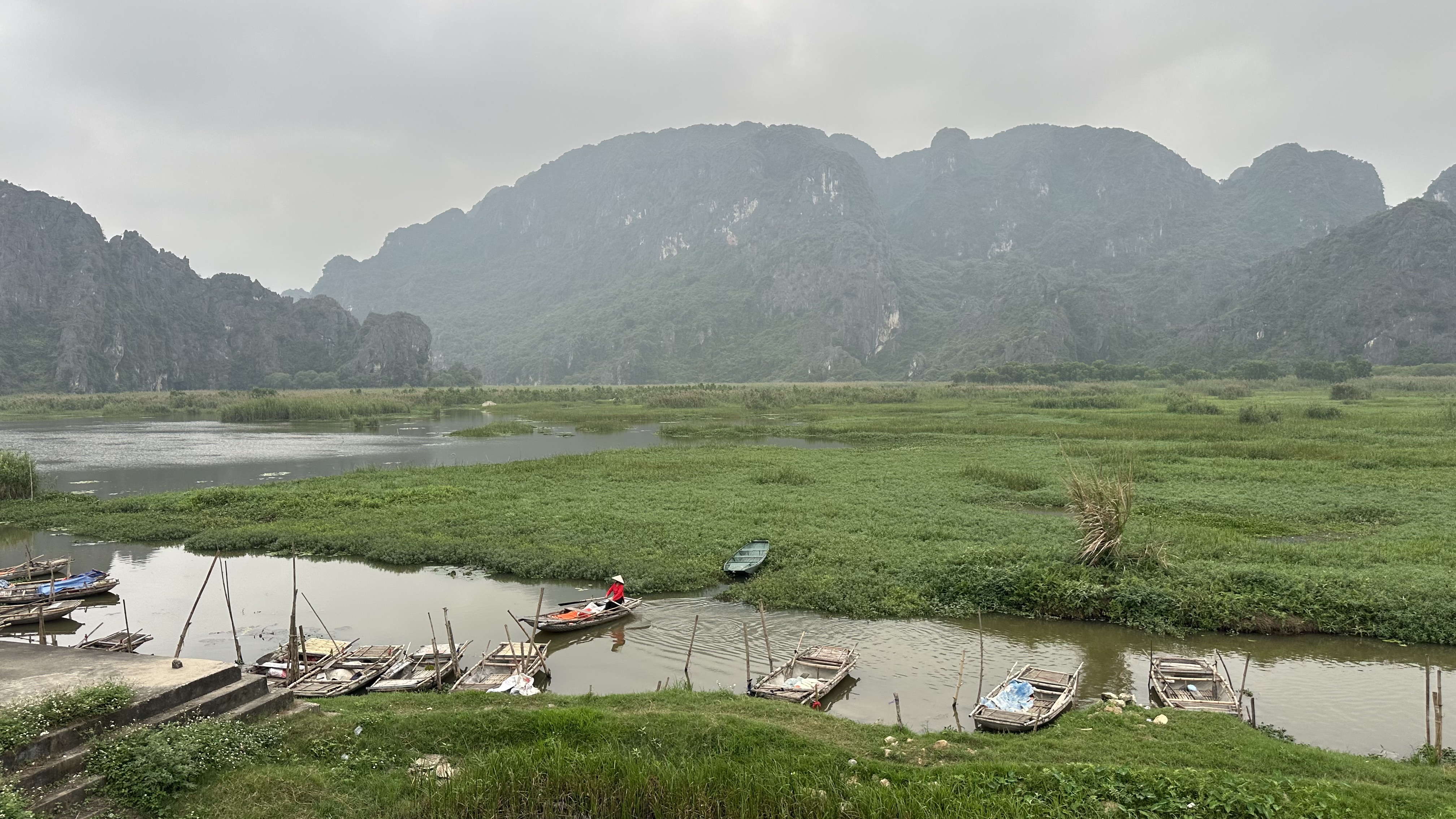 Towering limestone karsts reflecting in the still waters of Van Long